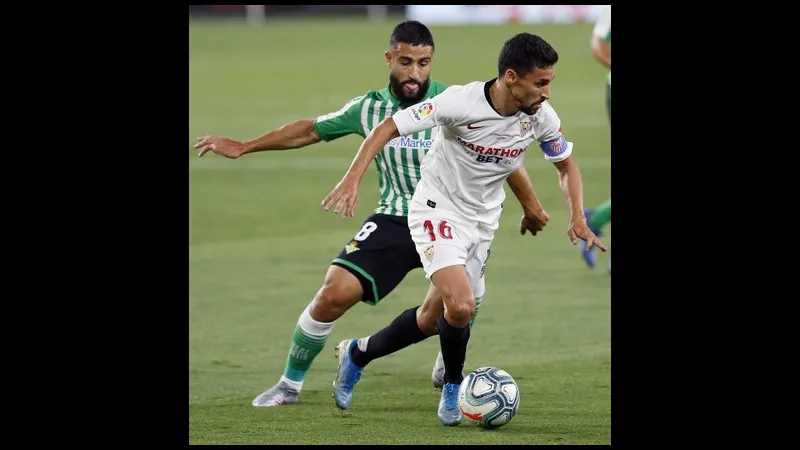 Cầu thủ của Sevilla đi bóng qua hậu vệ của Real Betis trong trận đấu Cầu thủ của Sevilla đi bóng qua hậu vệ của Real Betis trong trận đấu